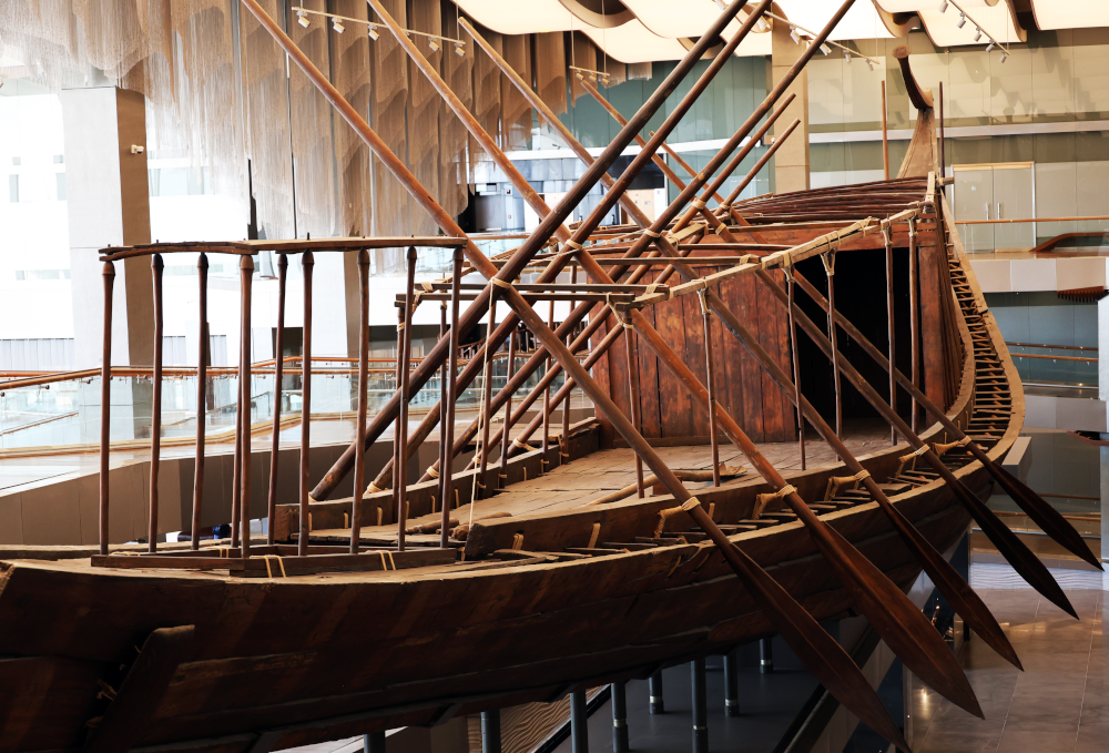 La barque de Khéops au Grand Egyptian Museum, photo. G. Grégor ; agrandissement : la barque de Khéops lors de sa découverte, 1954. 