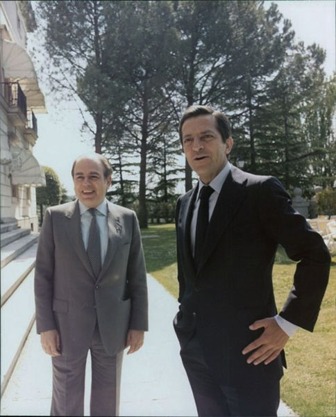 Le Premier ministre espagnol Adolfo Suárez reçoit le secrétaire général de la Convergence démocratique de Catalogne, Jordi Pujol, au Palais de la Moncloa (Madrid), le 16 mars 1978. Agrandissement : le roi et la reine d'Espagne ainsi qu'Adolfo Suárez écoutent l'hymne national lors de la cérémonie d'inauguration de la Cour constitutionnelle, le 12 juillet 1980.