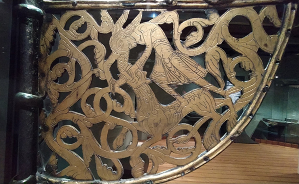 Pavillon de navire ou girouette, provenant de Dausdal, Innlandet, 1110-1160. Bronze dor&eacute;, 30 &times; 38,7 cm. Mus&eacute;e d?histoire culturelle, Oslo. (&copy; SWG). Agrandissement : St&egrave;le orn&eacute;e de l?&icirc;le de Gotland, VIIIe ? Xe si&egrave;cle. Bas-relief calvaire, 125 &times; 65 cm. (&copy; SWG) 